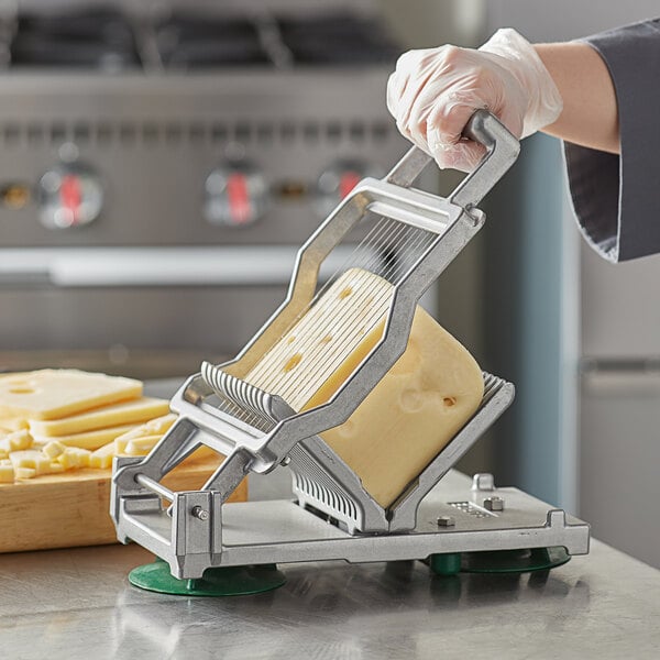 A person using a Garde cheese slicer to cut cheese.