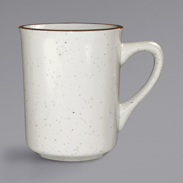 An International Tableware ivory stoneware coffee cup with a brown speckled rim and handle.