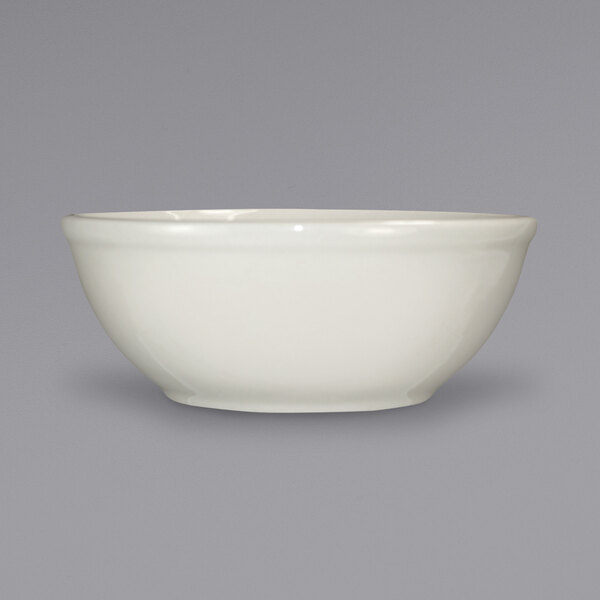 A close up of an International Tableware Roma ivory stoneware bowl.