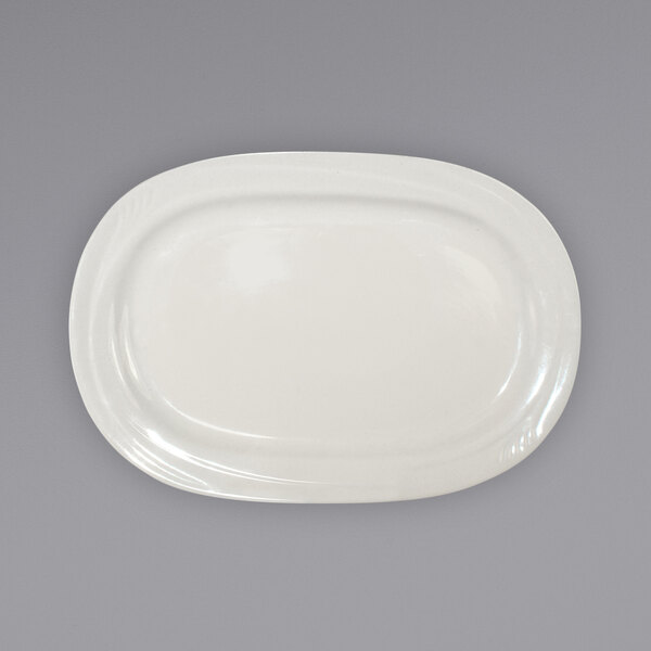 An International Tableware ivory stoneware oval platter with an embossed rim on a gray background.