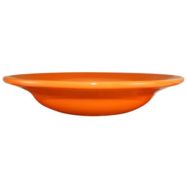 An orange International Tableware stoneware deep rim soup bowl.