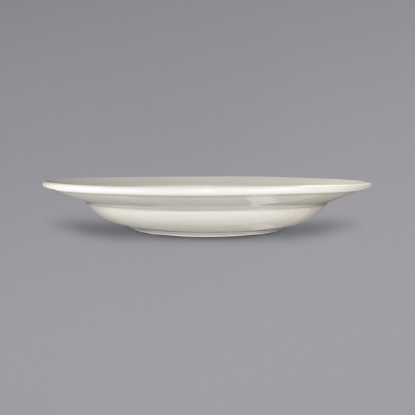 A close up of an International Tableware ivory stoneware pasta bowl with a rolled edge.