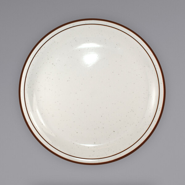 An International Tableware ivory stoneware plate with a brown speckled narrow rim.