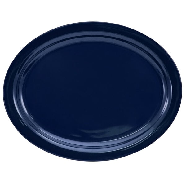 A cobalt blue stoneware oval platter with a narrow rim.