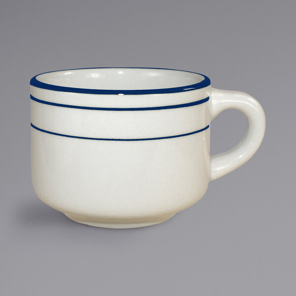 An ivory stoneware coffee cup with a white handle and blue bands.