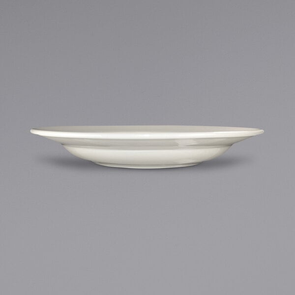 A close up of a white stoneware pasta bowl with a rolled edge.