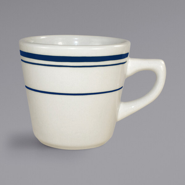 An International Tableware Catania tall stoneware cup with blue stripes on the top and bottom.