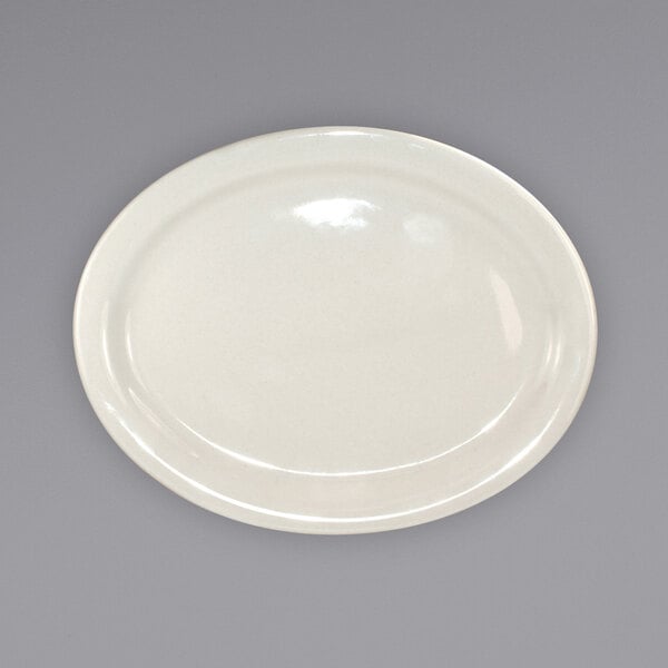 An International Tableware Valencia ivory stoneware platter with a narrow rim on a gray surface.