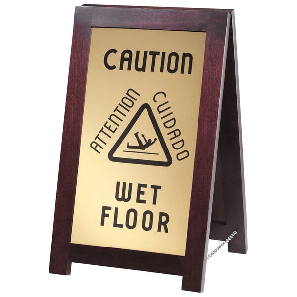 A Cal-Mil wooden wet floor sign with "WET FLOOR" on both sides.