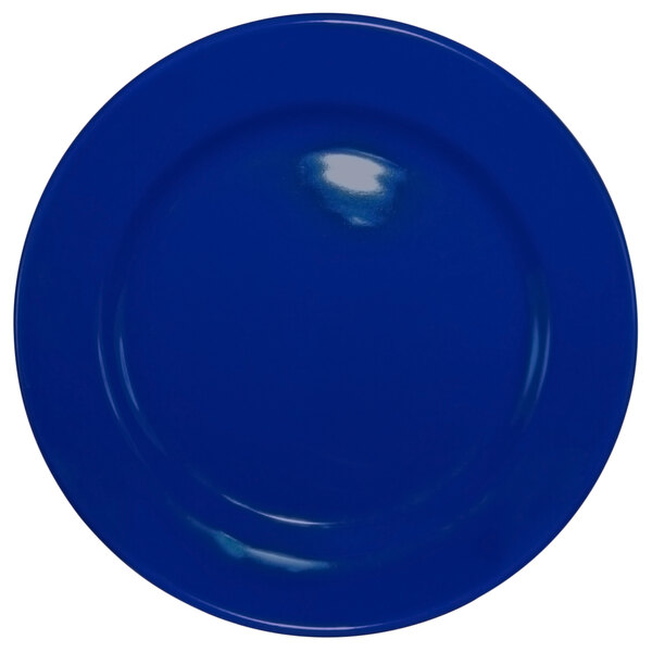 A cobalt blue stoneware plate with a wide rim and rolled edge.