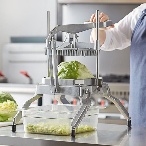 A woman using a Choice Prep square lettuce chopper to cut lettuce on a counter.