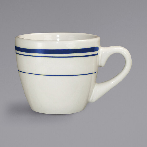 An ivory stoneware espresso cup with blue bands on the handle.