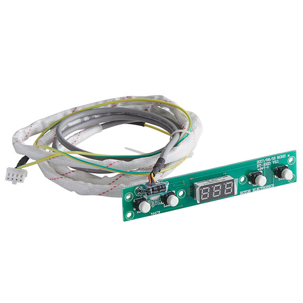 A green circuit board with a digital display and white wires.