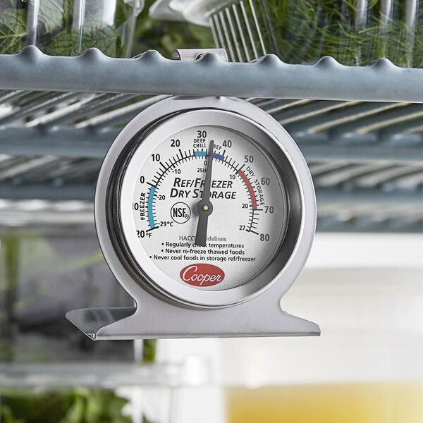 A Cooper-Atkins refrigerator thermometer on a shelf.