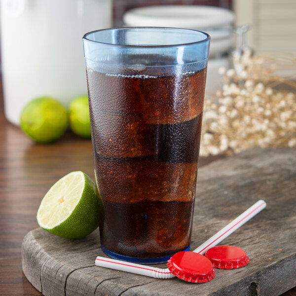 A Carlisle blue plastic tumbler filled with soda and ice with a lime.