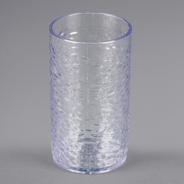 A Carlisle clear plastic tumbler with a pebble texture and blue rim.