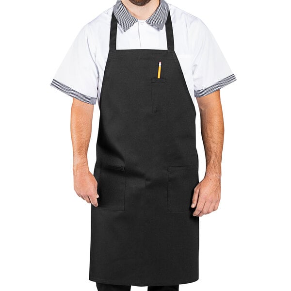 A man wearing a black Uncommon Chef bib apron with white trim.