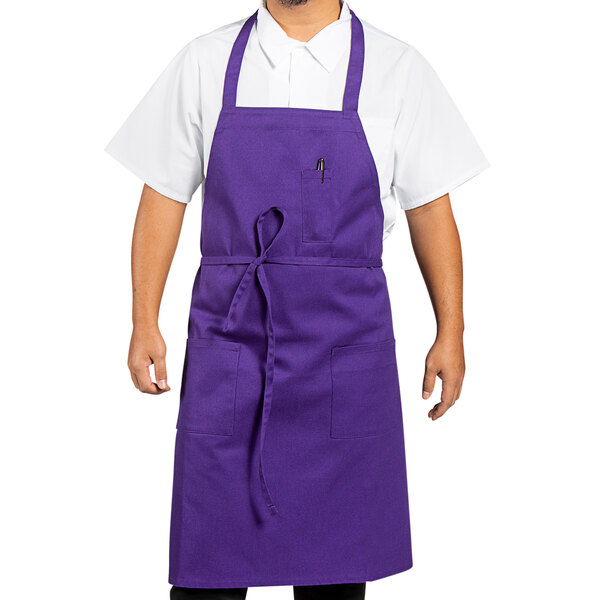 A man wearing a Uncommon Chef purple bib apron.