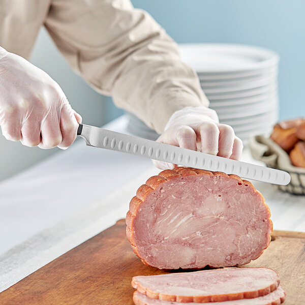 A person using a Wusthof Classic forged knife to slice ham.