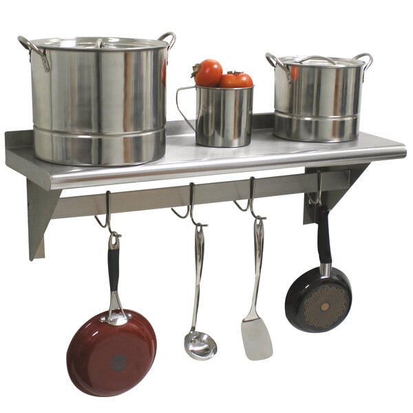An Advance Tabco stainless steel wall shelf with pots and pans on it.