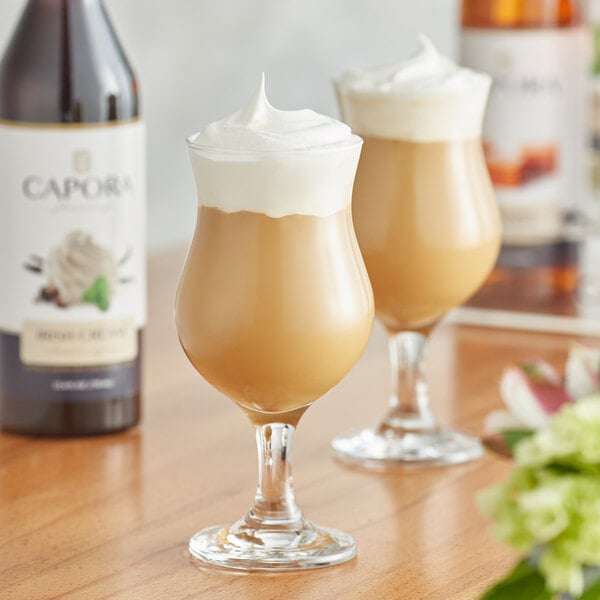 Two glasses of coffee with Capora Irish Cream flavoring syrup and whipped cream on top.
