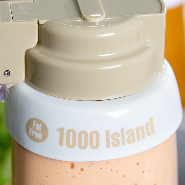 A Tablecraft white plastic salad dressing dispenser collar with beige lettering on it.