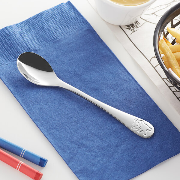 An Acopa medium weight stainless steel teaspoon on a napkin.