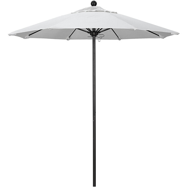 A white California Umbrella on a black pole.