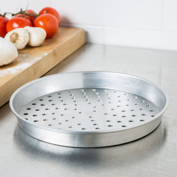A silver American Metalcraft pizza pan with holes in it.