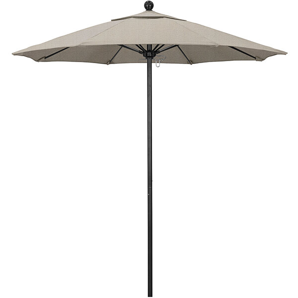 A woven granite fabric California Umbrella with a black pole on a table.