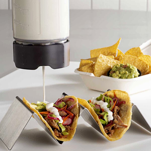 A Server ProPortion single-tip squeeze bottle dispensing white sauce on a taco.