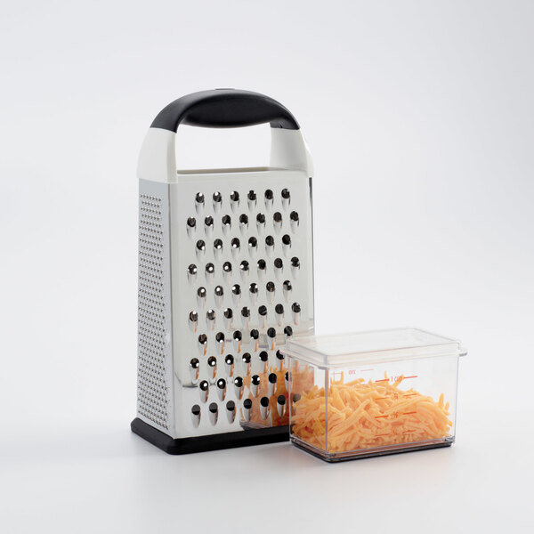 A OXO stainless steel box grater with shredded cheese in a container.