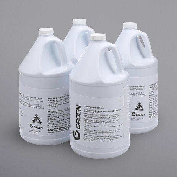 A group of white plastic jugs with Groen Deliming Cleaner labels.
