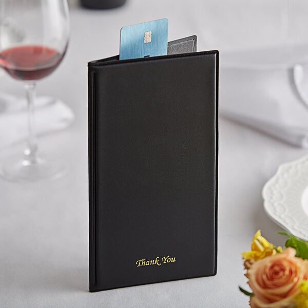 An American Metalcraft black bill presenter on a table with a card inside.