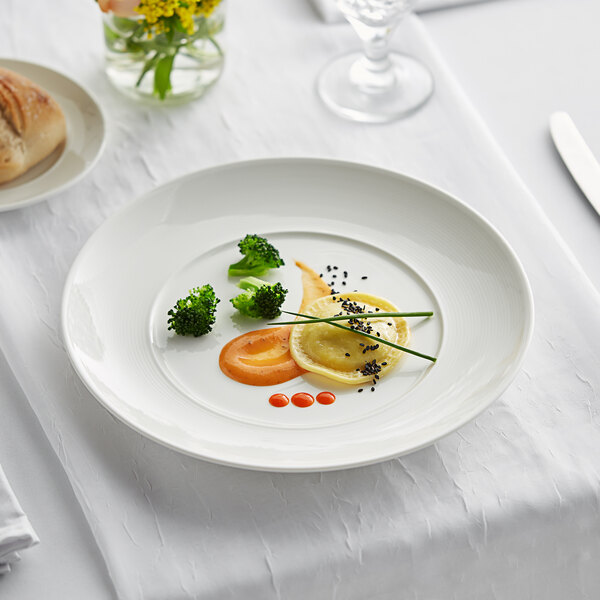 A white Acopa Liana porcelain plate with food on it.