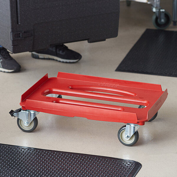 A red plastic Cambro Camdolly with wheels.