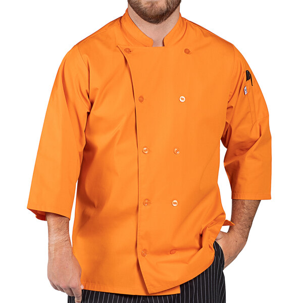 A man wearing a Uncommon Chef carrot orange chef coat with 3/4 length sleeves.