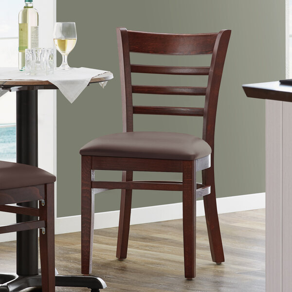 A Lancaster Table & Seating mahogany wood restaurant chair with a dark brown vinyl seat.