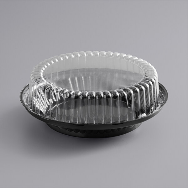 A black plastic pie container with a clear lid.