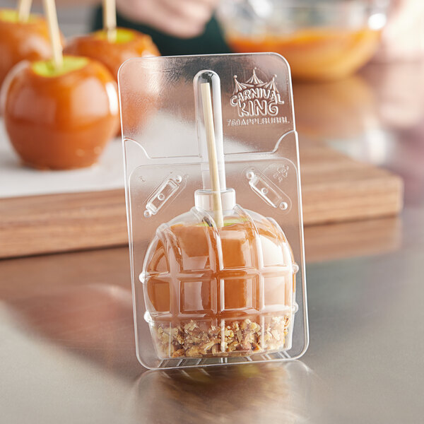 A Carnival King candy apple in a plastic container.
