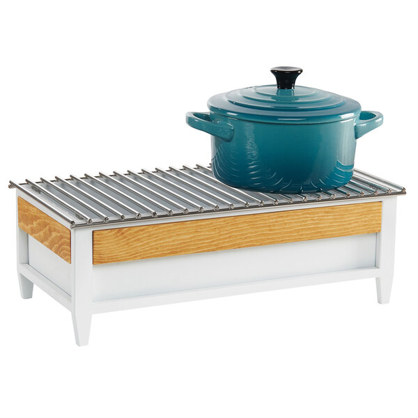 A white and wood chafer alternative with a metal grate holding a blue pot.