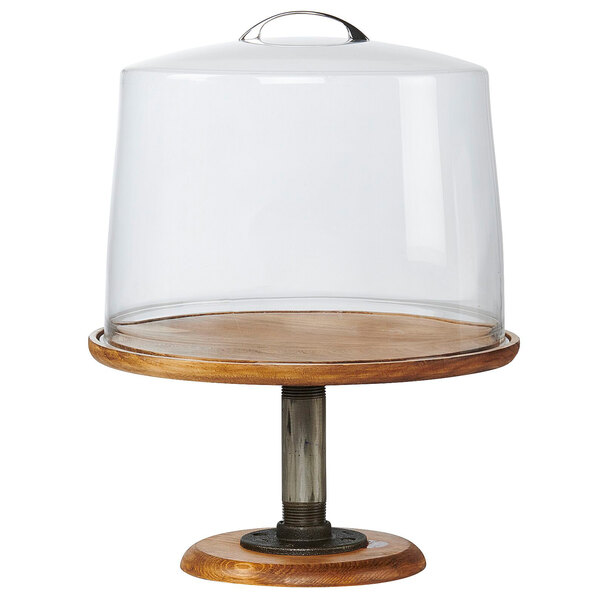 A glass cake stand with a wooden base and glass dome on a wooden stand.
