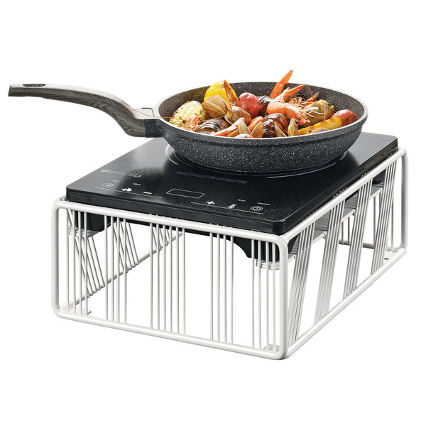 A Cal-Mil Portland white countertop induction cooker with a pan of seafood on it.