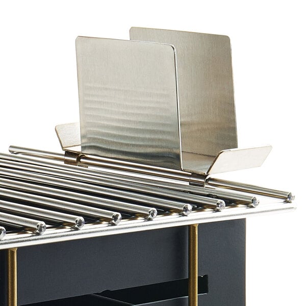 A metal Cal-Mil lid holder attachment on a metal rack.