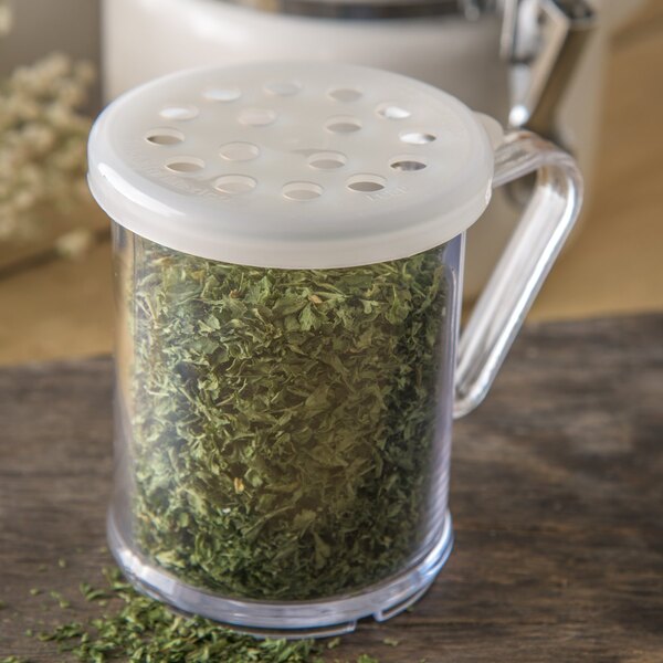 A Carlisle polycarbonate shaker with a translucent lid filled with green herbs.