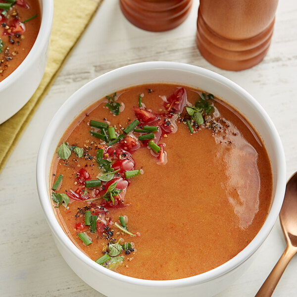 A bowl of Knorr Creamy Tomato and Roasted Red Pepper soup with spices and herbs.