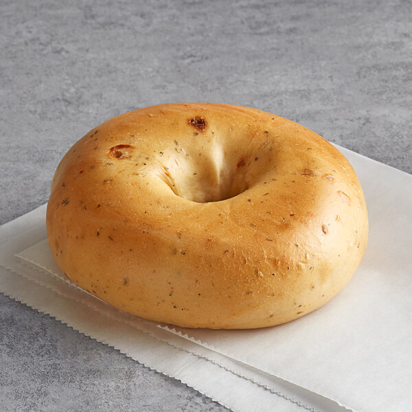 An Original Bagel New York Style Sun Dried Tomato bagel with a hole in the middle on a napkin.