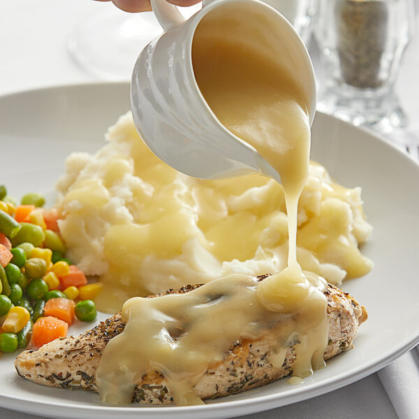 A plate of mashed potatoes and chicken covered in Knorr chicken gravy.