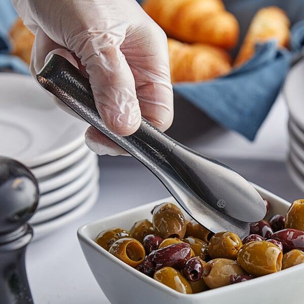 A person using American Metalcraft black vintage tongs to serve olives.