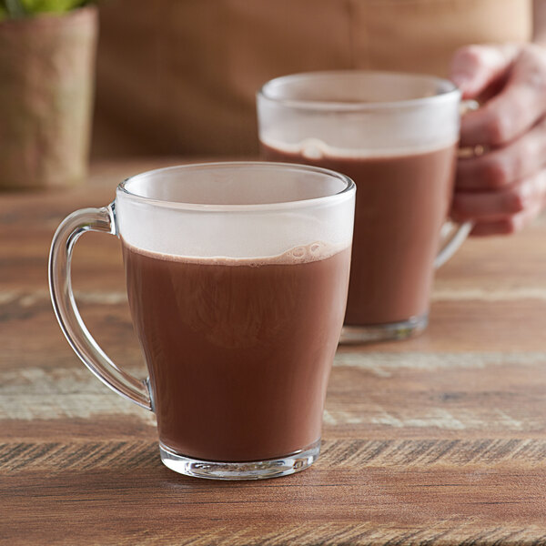 A close-up of a Duralex glass mug filled with hot chocolate.